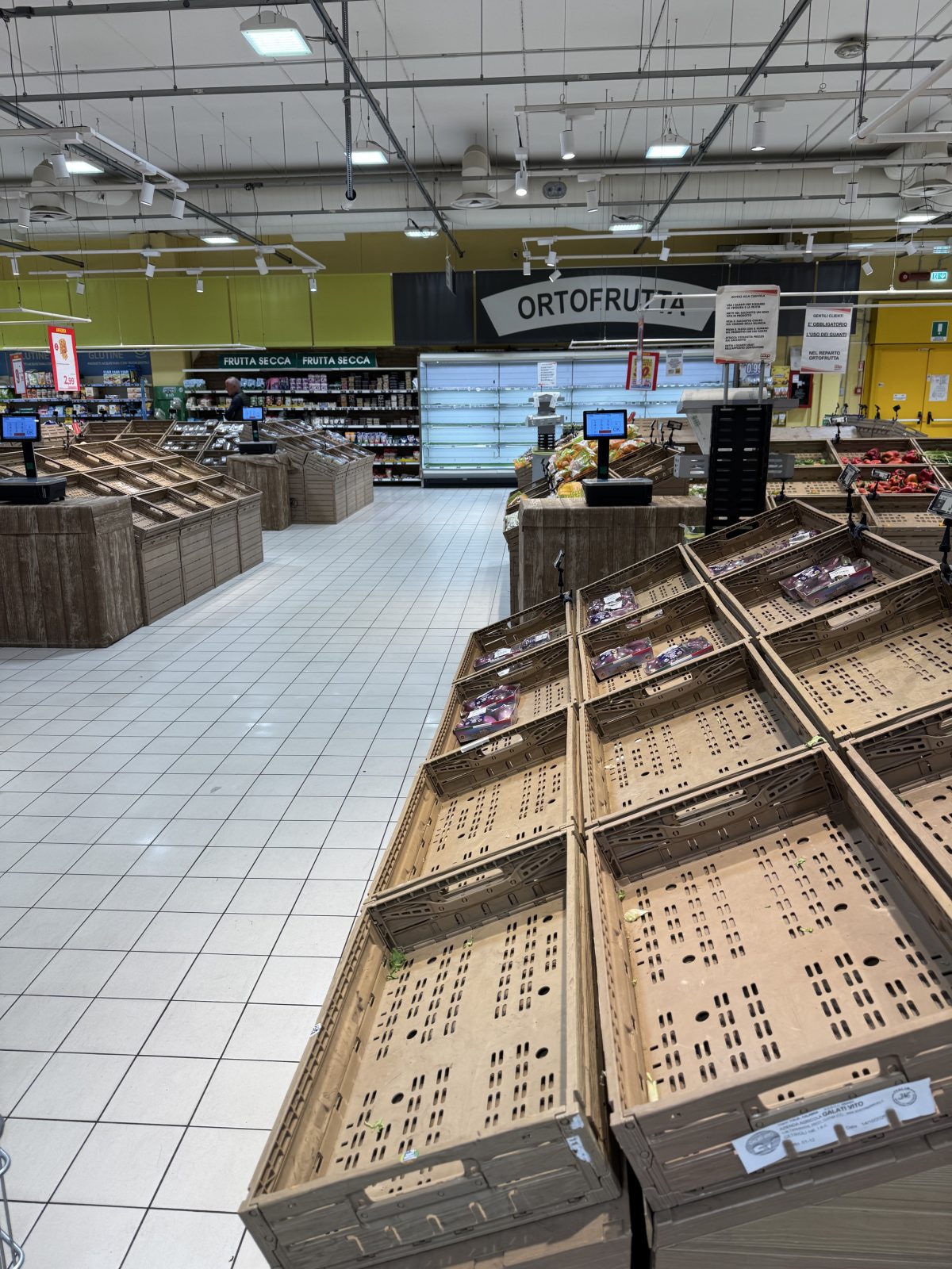 Assortimento ridotto e numerose cassette vuote nel reparto ortofrutta di un supermercato di Rende.